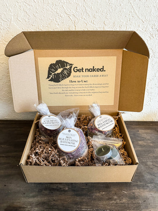 bath gift box set in kraft box with 3 different bath soaks and tea light candles included on wooden surface