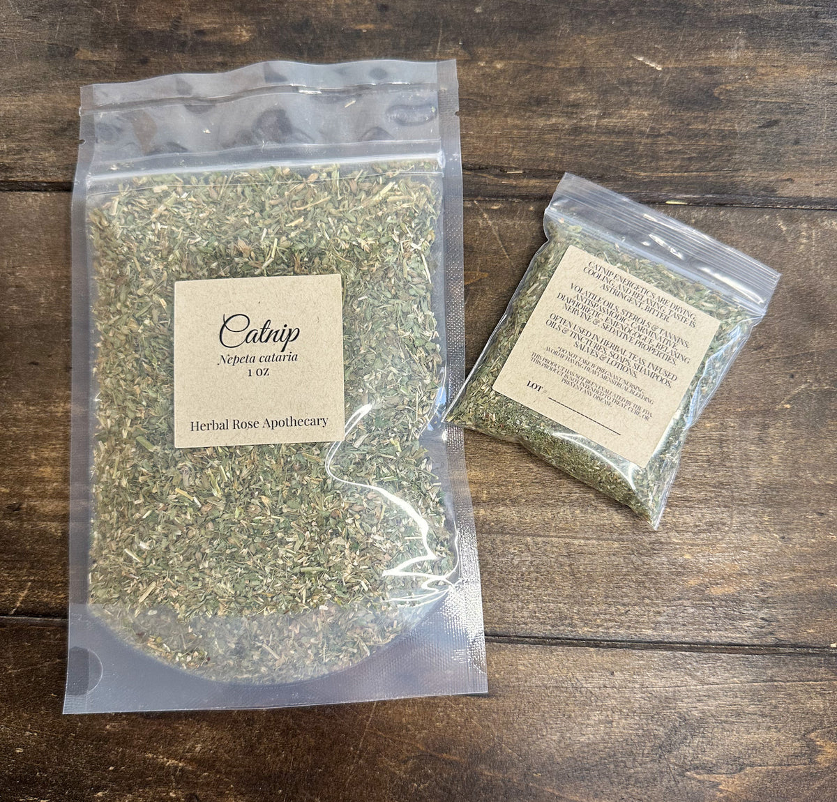 Two packages of catnip dried herbs with labels 1oz and 8g on a wooden surface