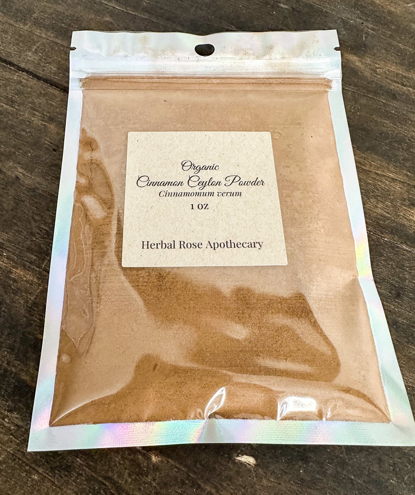 Package of organic cinnamon cinammon powder from Herbal Rose Apothecary on a wooden surface