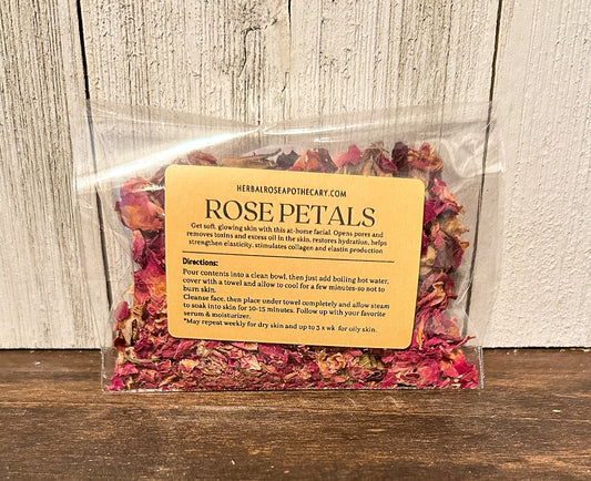 facial steamers rose with label showing directions and benefits, brown table with white wood background packaged in cellophane