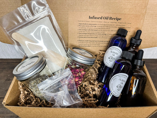 inside look whats included in infused oil box kit; directions card, 2 jars of herbs, cheesecloth with stir sticks, 2 funnels, 2 almond oil bottles, and 2 amber dropper bottles