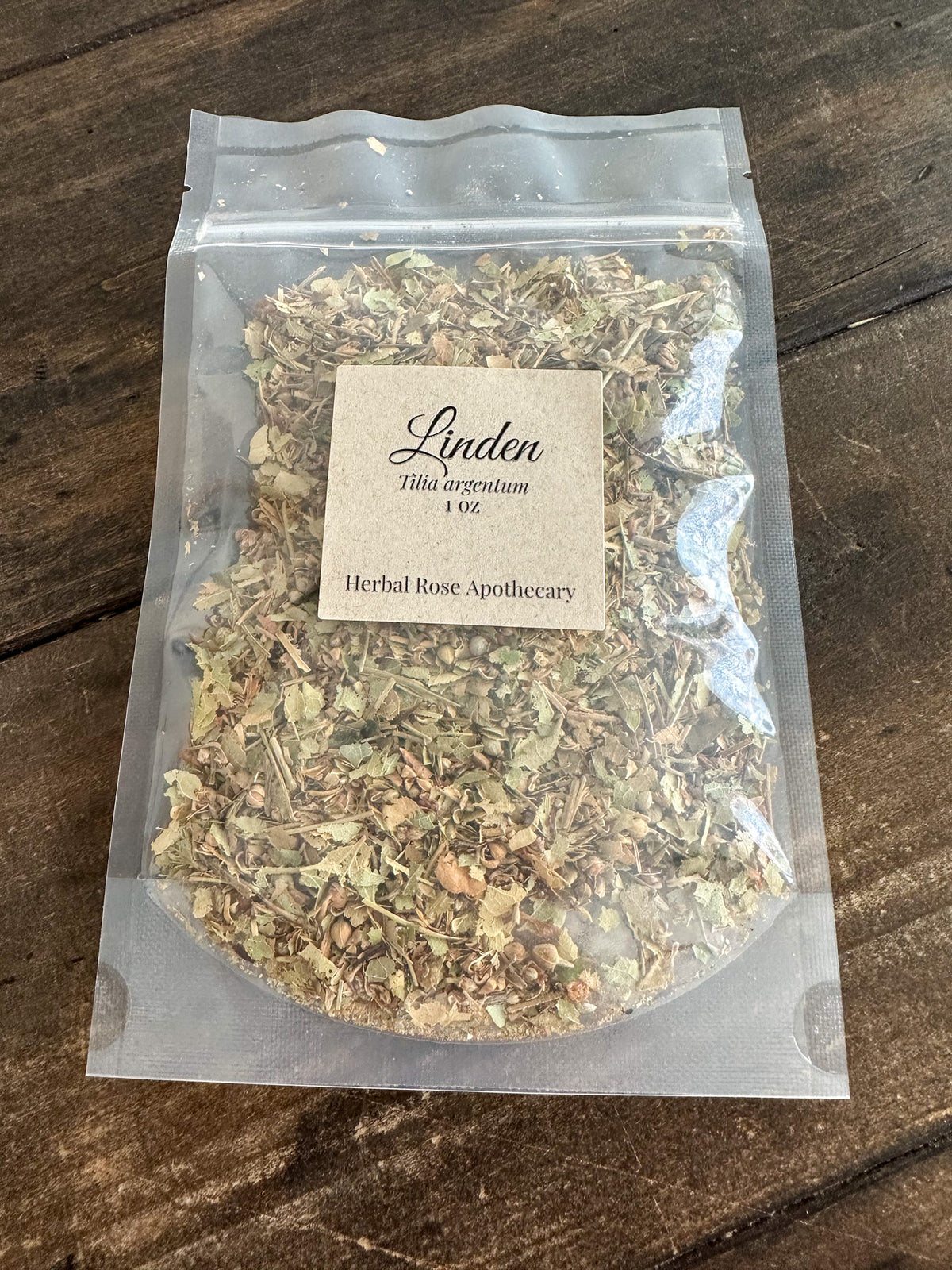 dried linden packaged into a clear resealable 1oz bag on a wooden surface