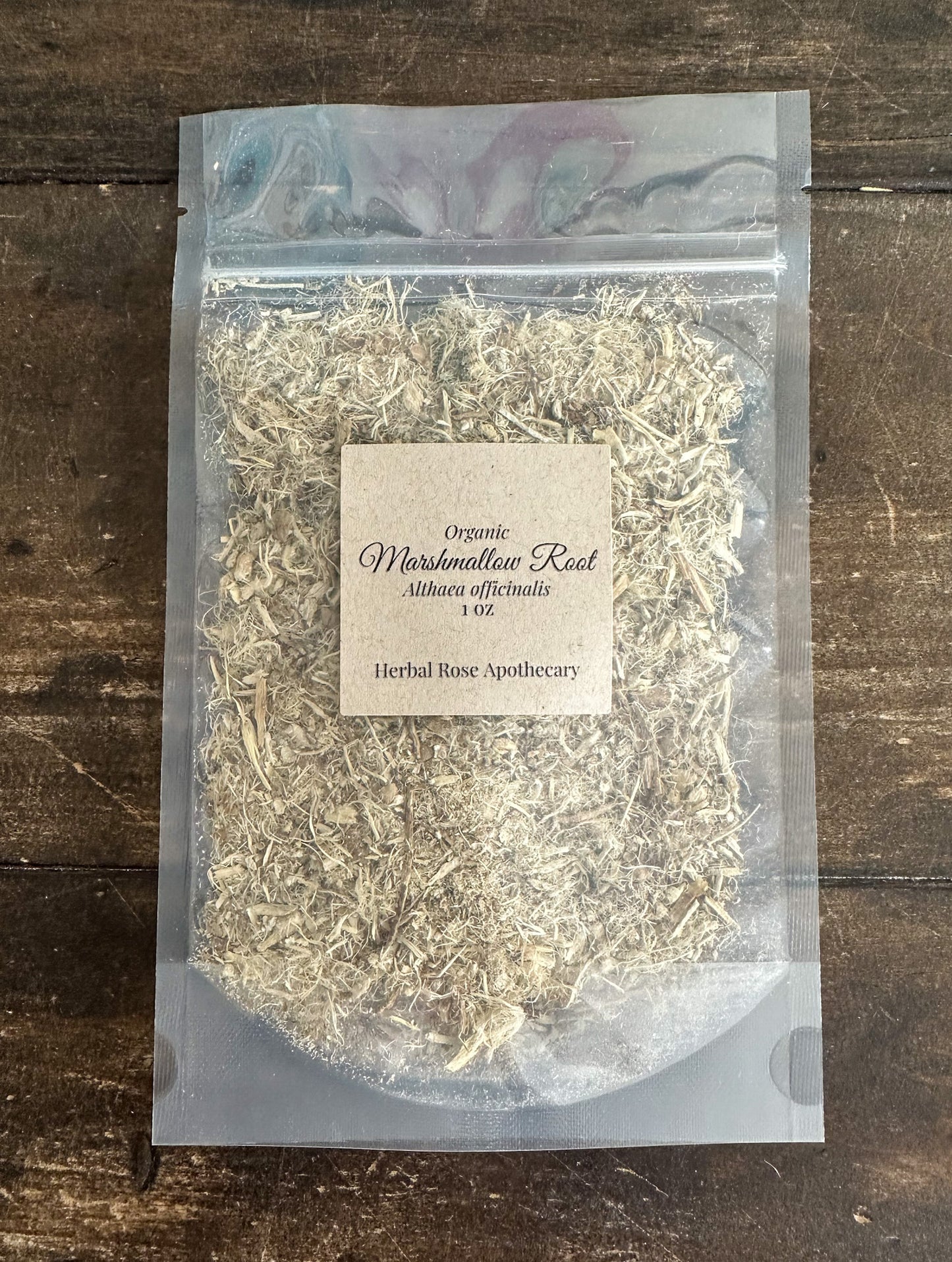 dried organic marshmallow root in a clear resealable 1oz bag on a wooden surface