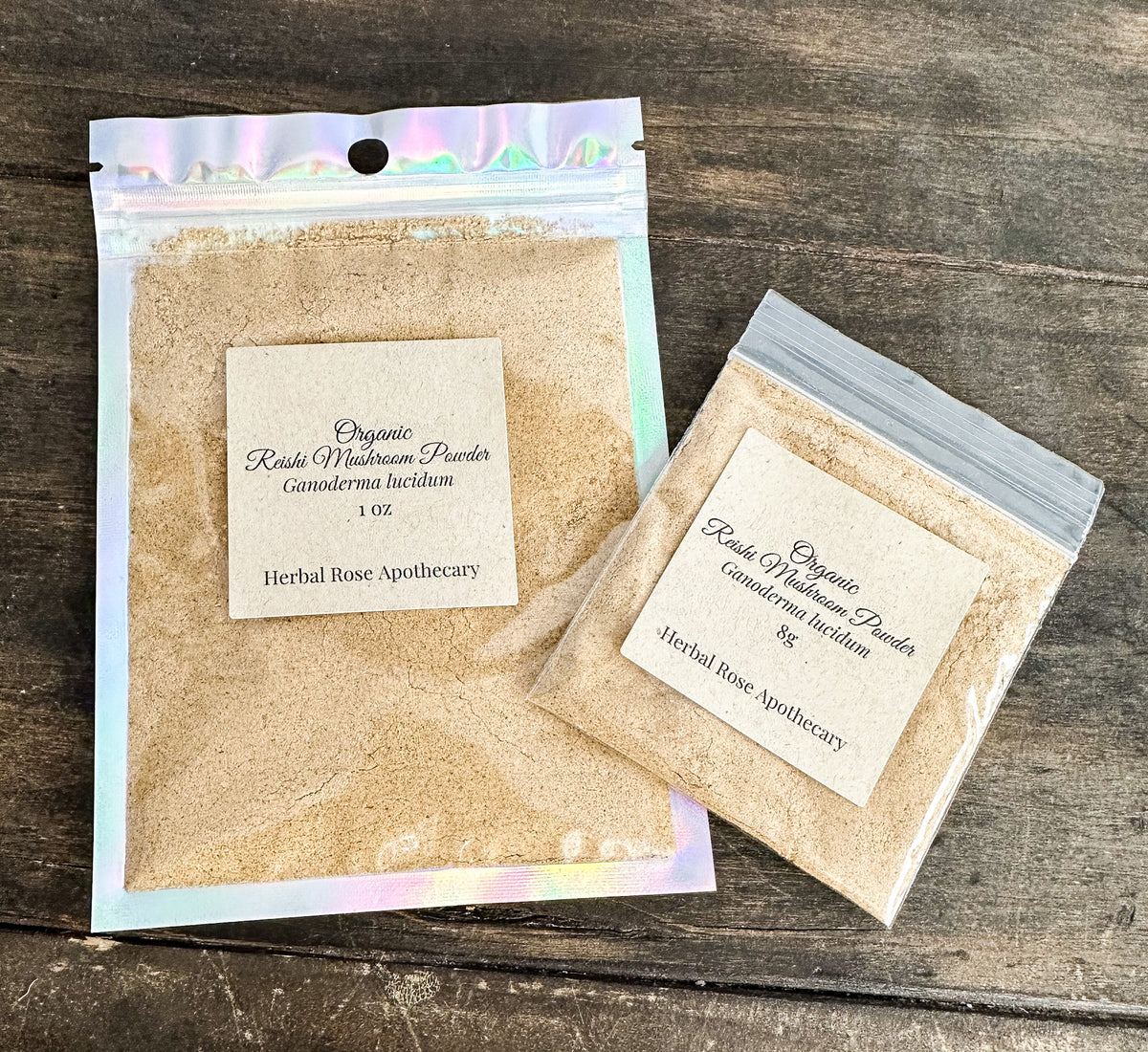 two packages of dried organic reishi mushroom powder in clear resealable bags from herbal rose apothecary on a wooden surface