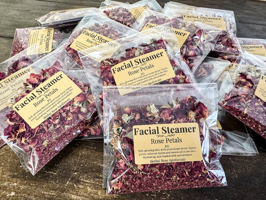 rose facial steamers packaged up in clear bags piled up on a wooden surface