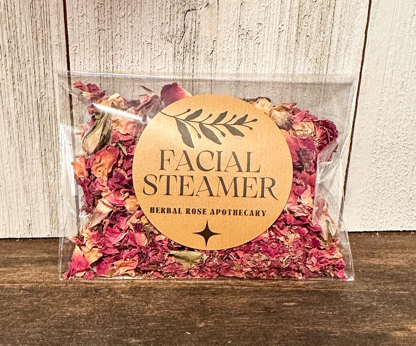 facial steamers rose, brown table with white wood background packaged in cellophane