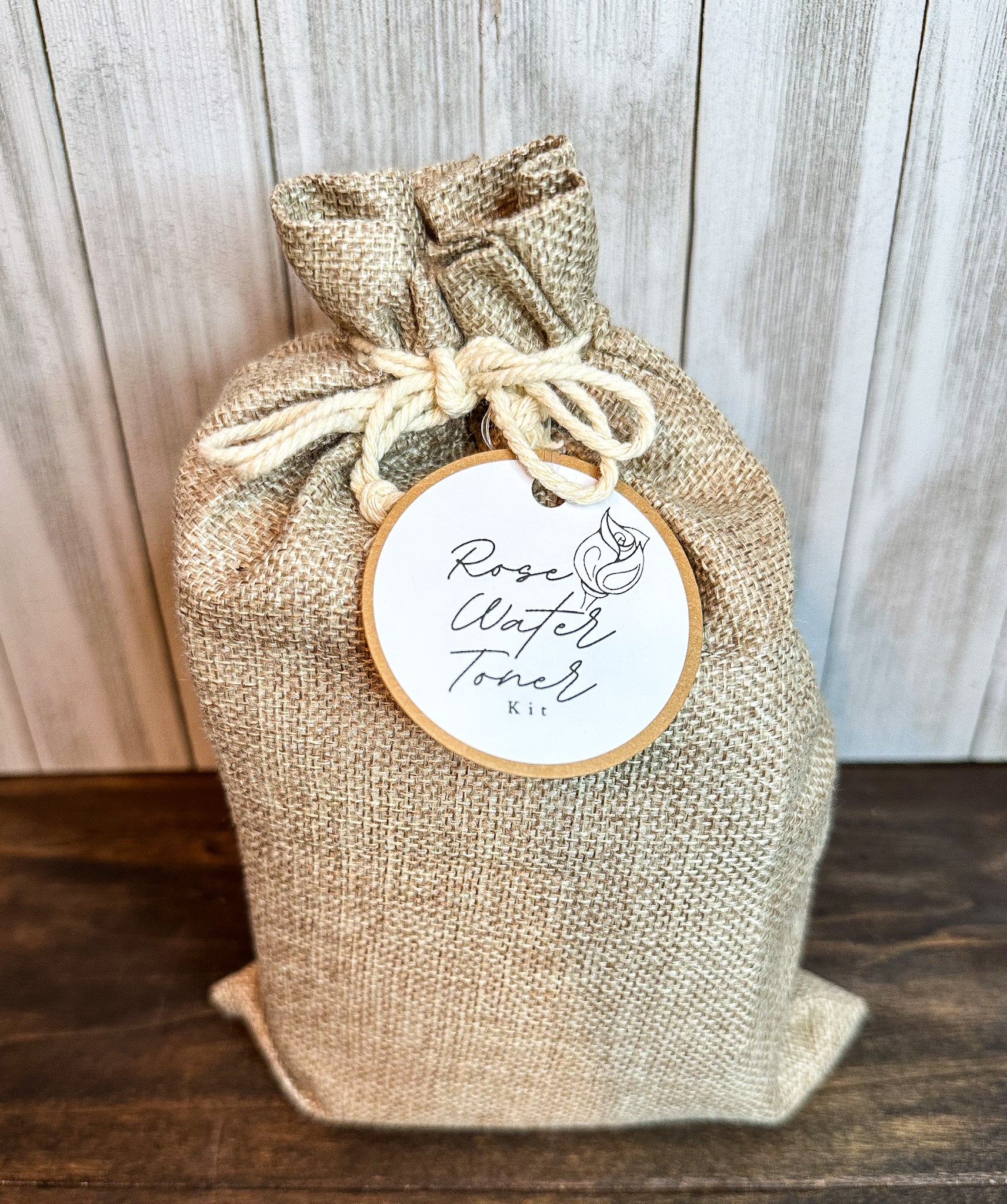 rose toner kit in canvas bag with brown and white round tag and gray and brown background