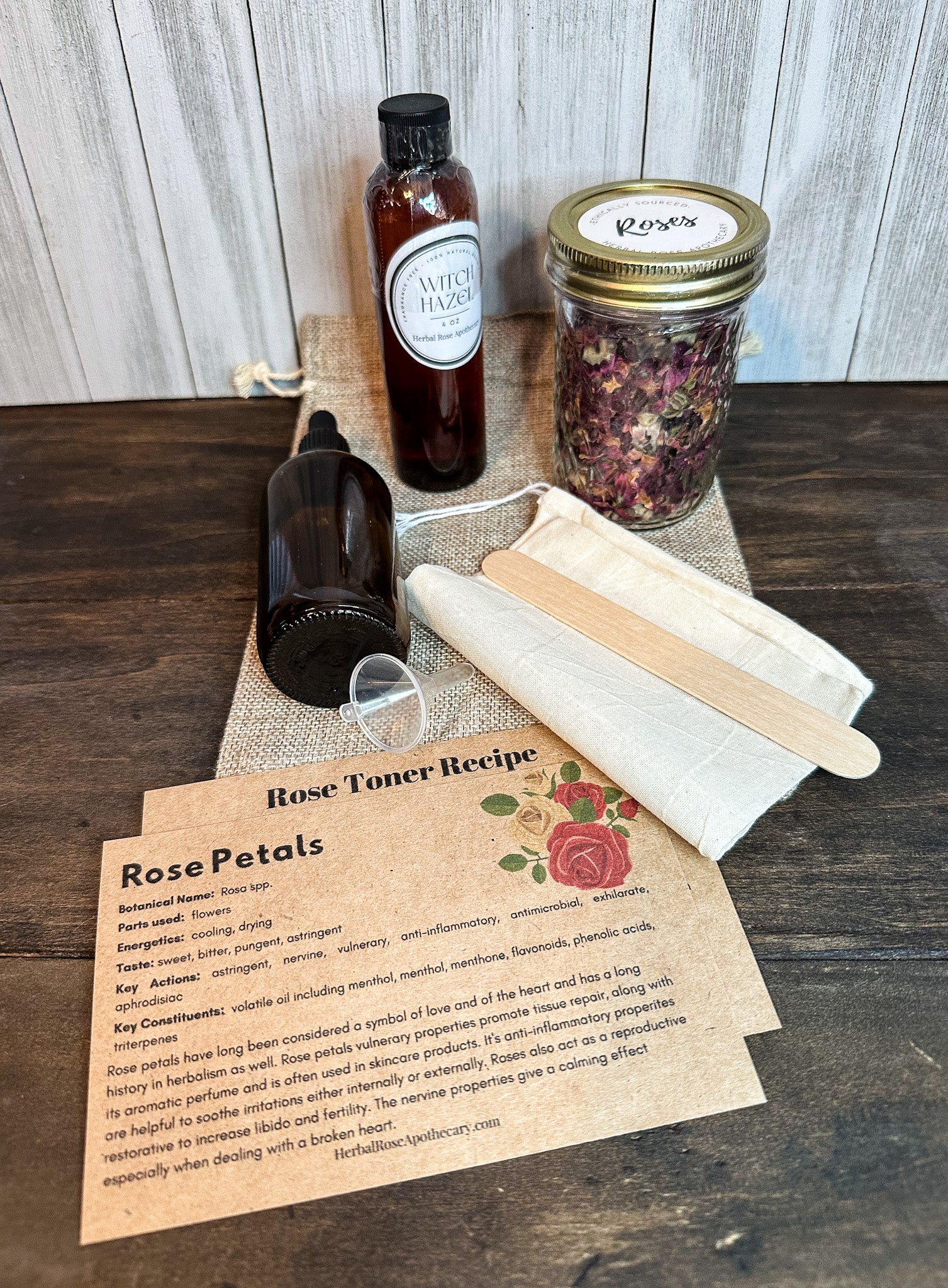 rose toner kit contents inside bag, witch hazel bottle, amber dropper bottle, jar of roses, stir stick, muslin strainer, directions and information on roses