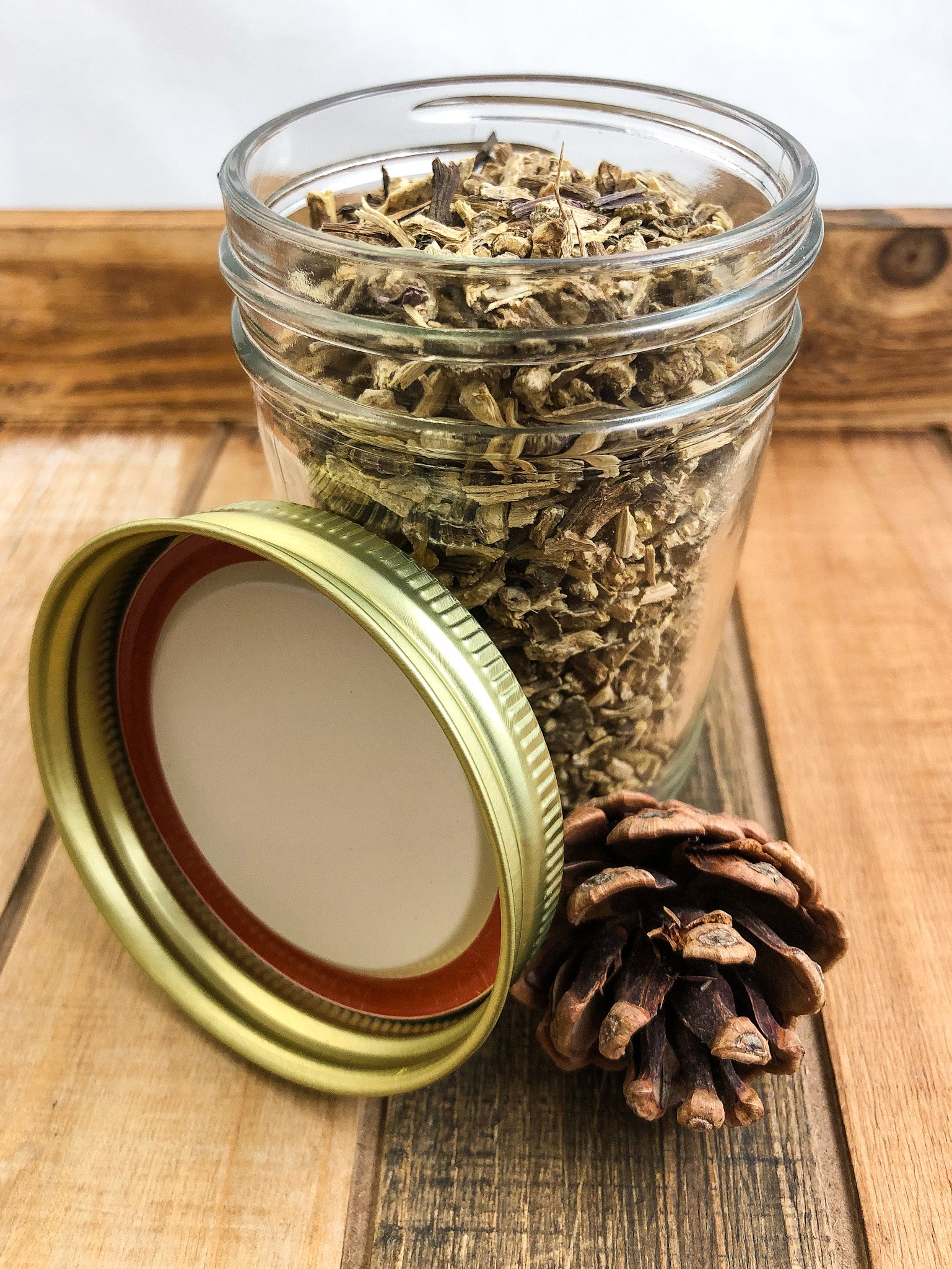 dried echinacea root in a clear mason jar with a wooden background