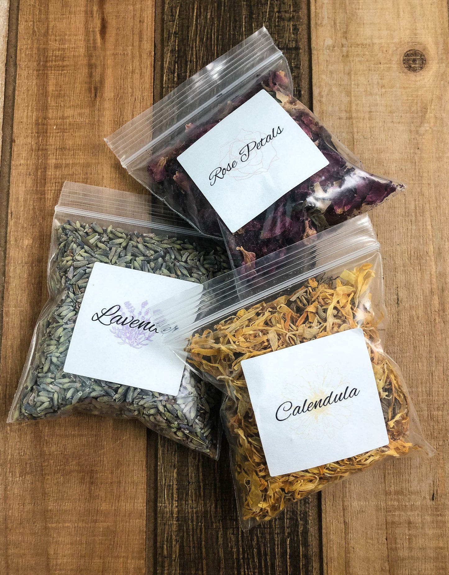 8g clear plastic bags of dried calendula, roses and lavender on a wooden background