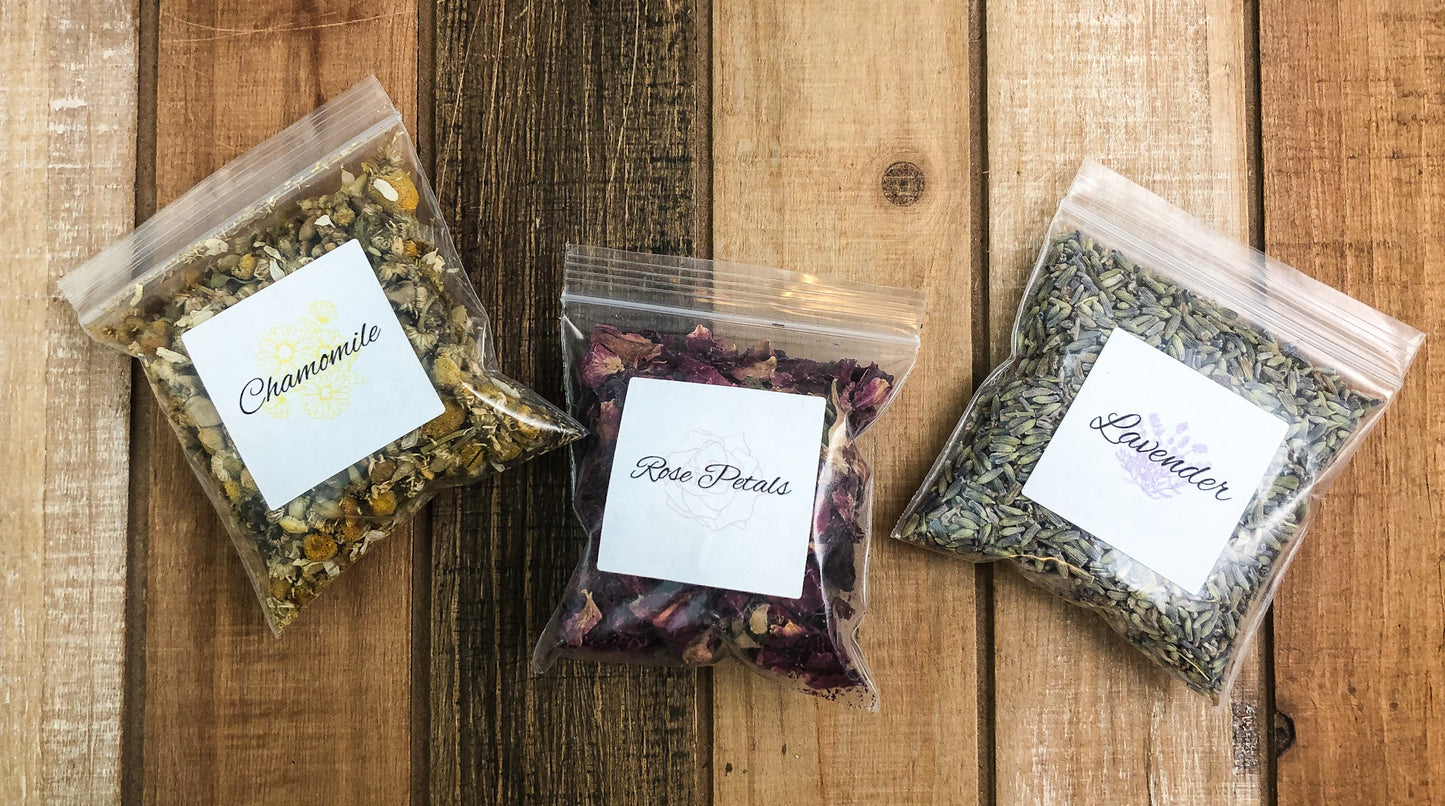 8g clear plastic bags of dried chamomile, roses, and lavender on a wooden background