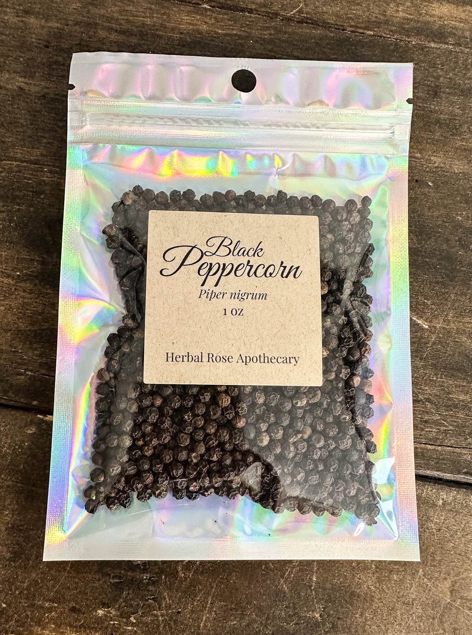 Packaging of black peppercorns with a label on a wooden surface