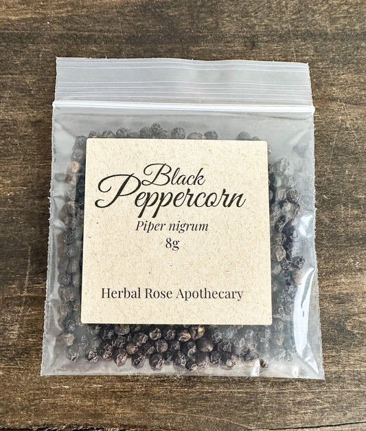 Packaged black peppercorns with a label on a wooden surface