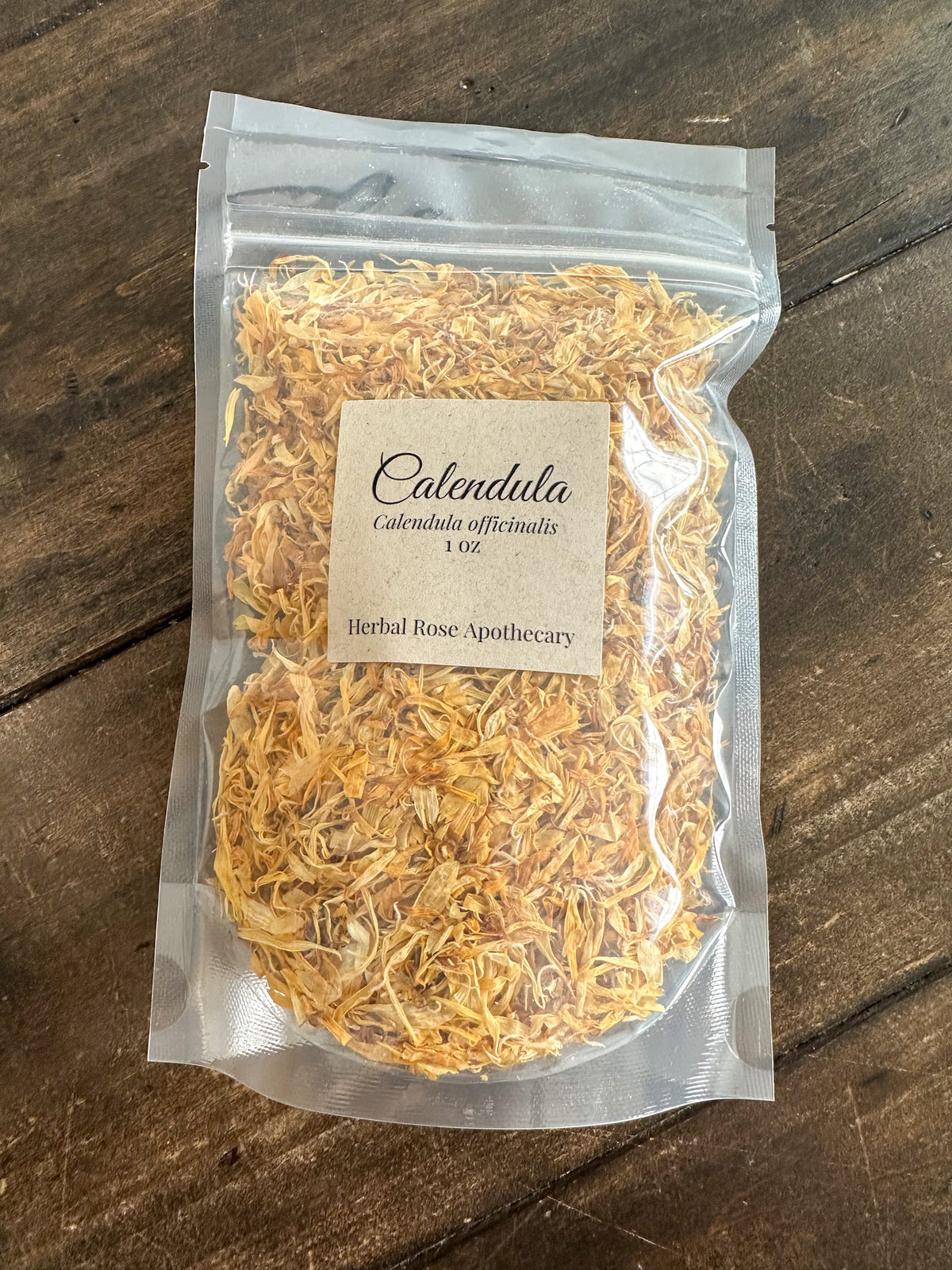 Packaged dried calendula flowers on a wooden surface