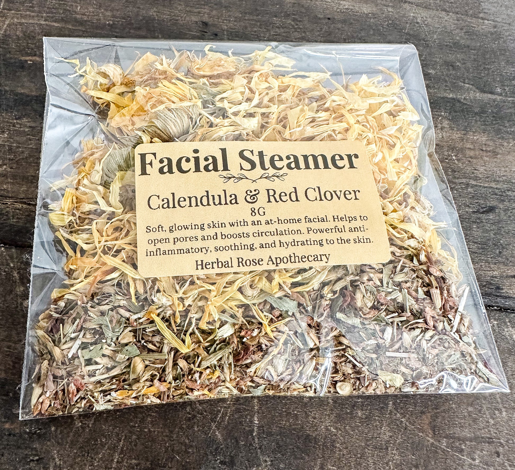 facial steamer with calendula and red clover on wooden background