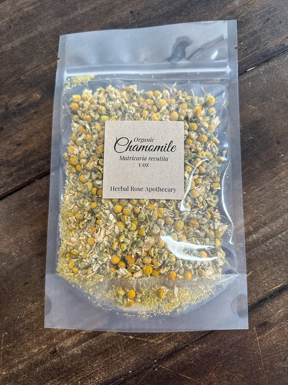dried organic chamomile 1oz bag in a clear resealable bag on a wooden surface