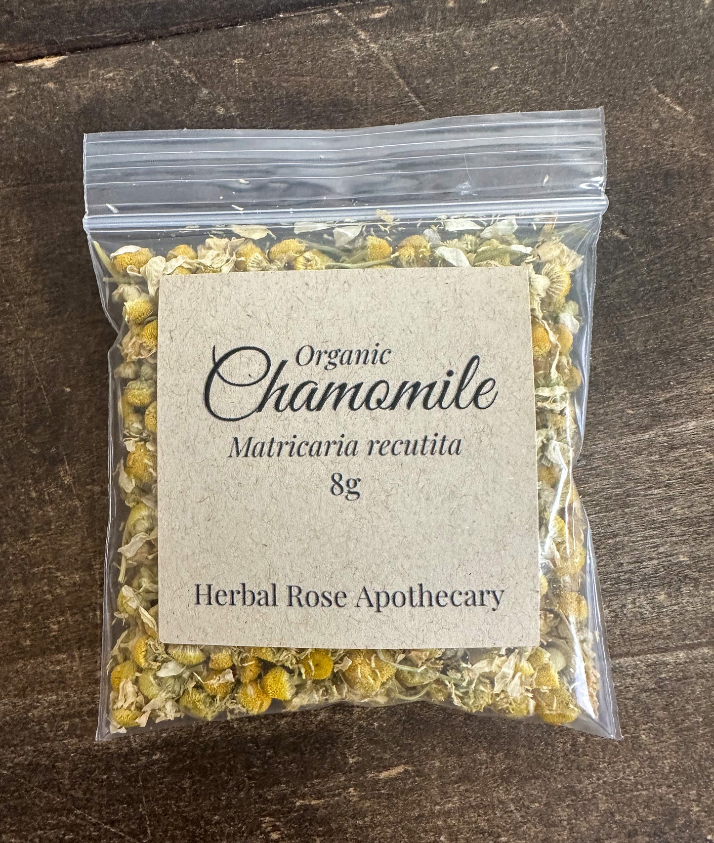 dried organic chamomile 8g bag in clear resealable bag on wooden surface