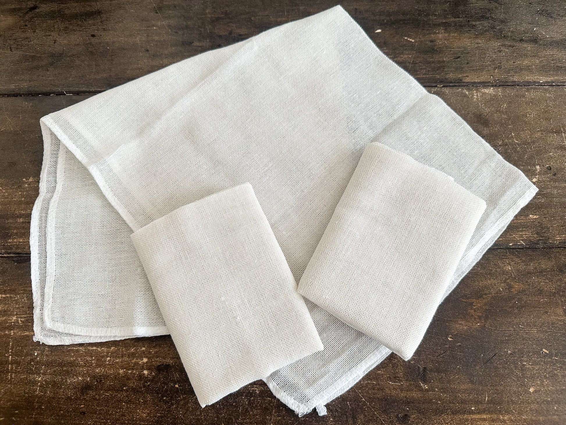 Set of beige cheesecloths on a wooden surface