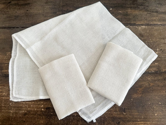 Set of beige cheesecloths on a wooden surface