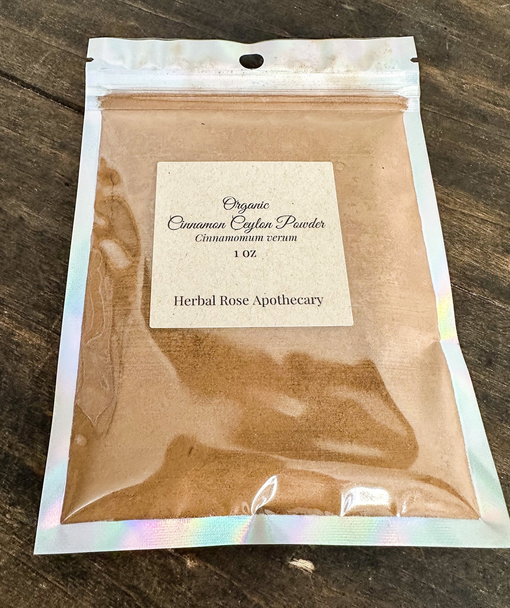 Package of organic cinnamon cinammon powder from Herbal Rose Apothecary on a wooden surface