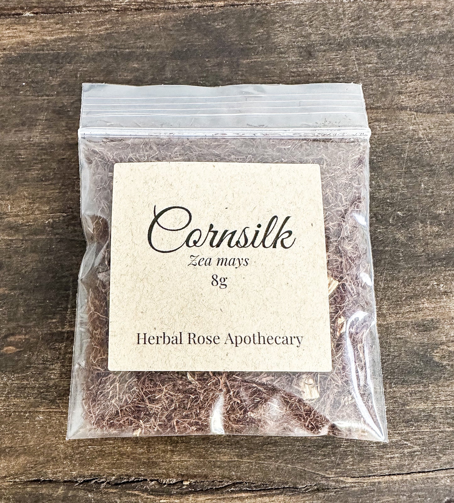 Packaged cornsilk from Herbal Rose Apothecary on a wooden surface