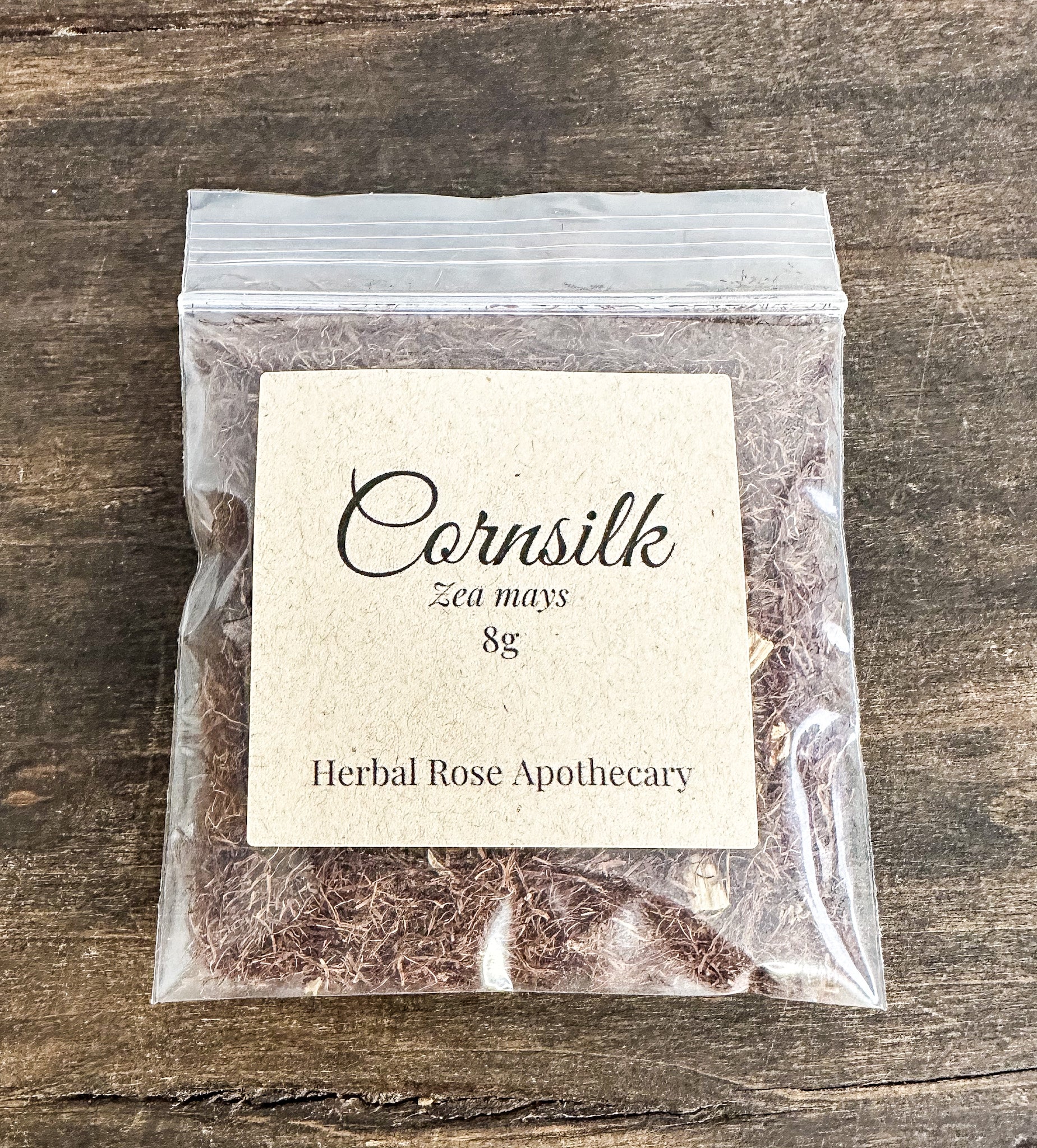 Packaged cornsilk from Herbal Rose Apothecary on a wooden surface