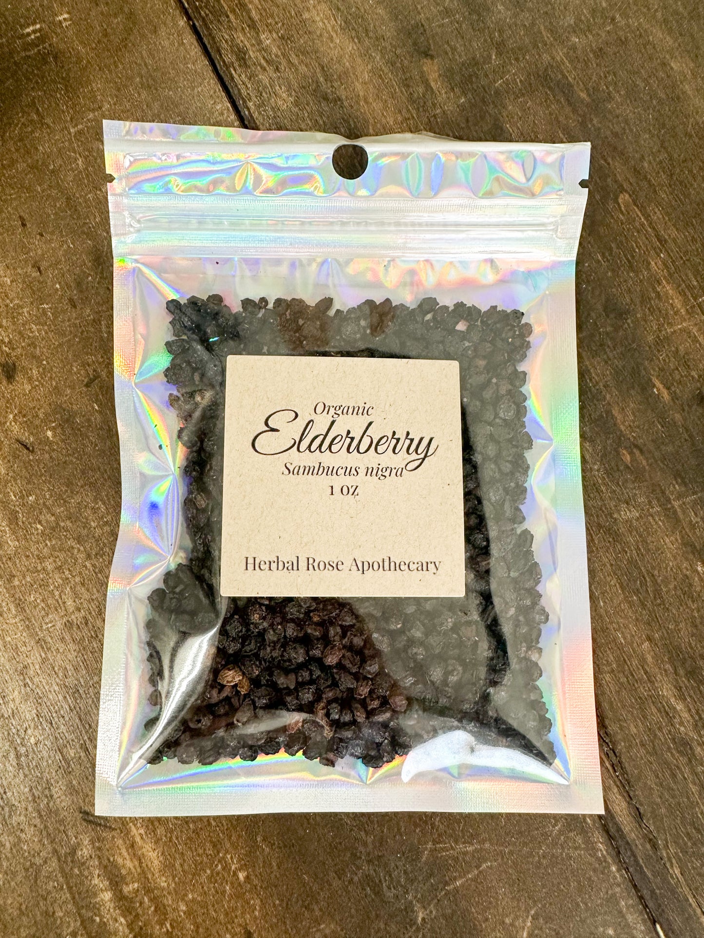 dried organic elderberry in holographic 1oz bag on a wooden surface