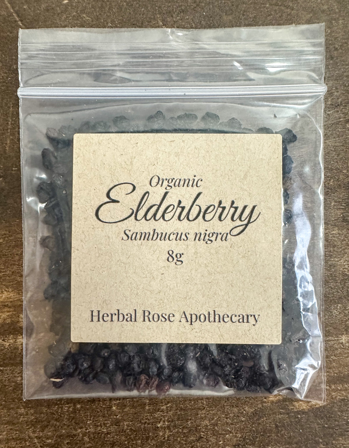 dried organic elderberry in 8g clear resealable bag on a wooden surface