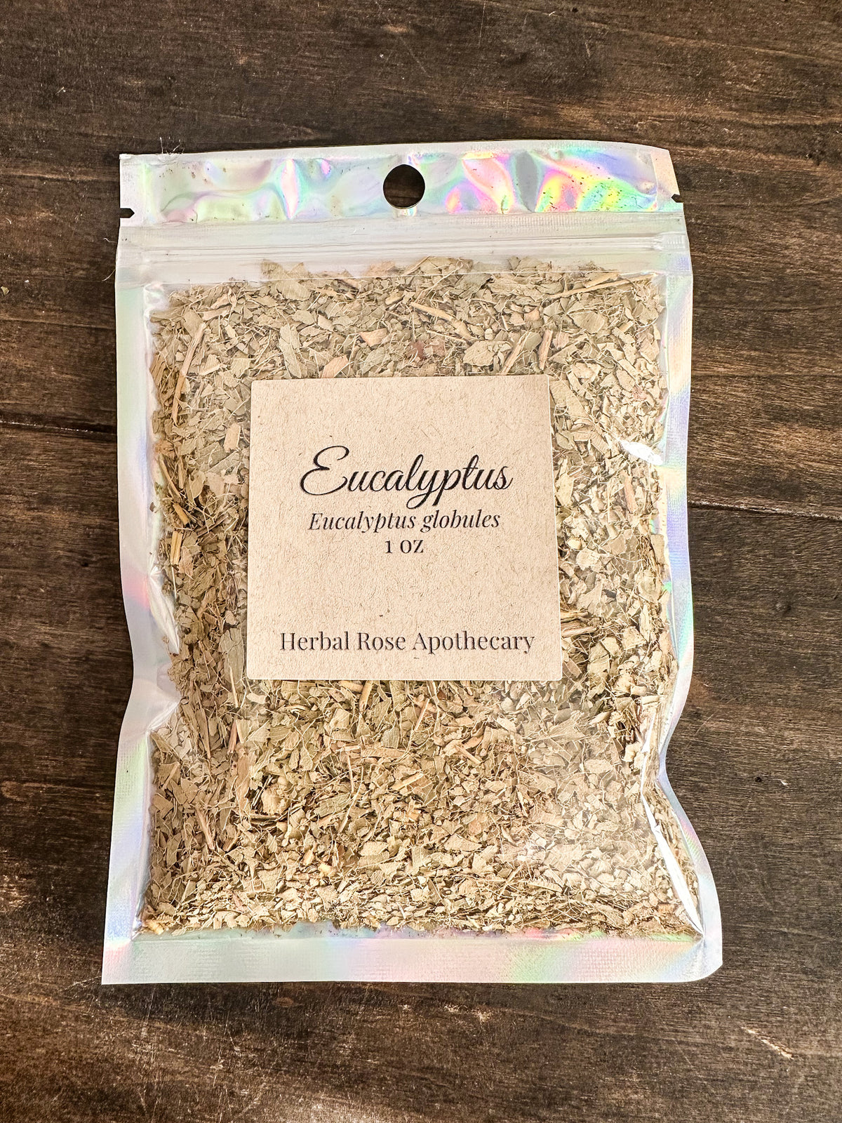 dried eucalyptus leaves in 1oz holographic bag on wooden surface