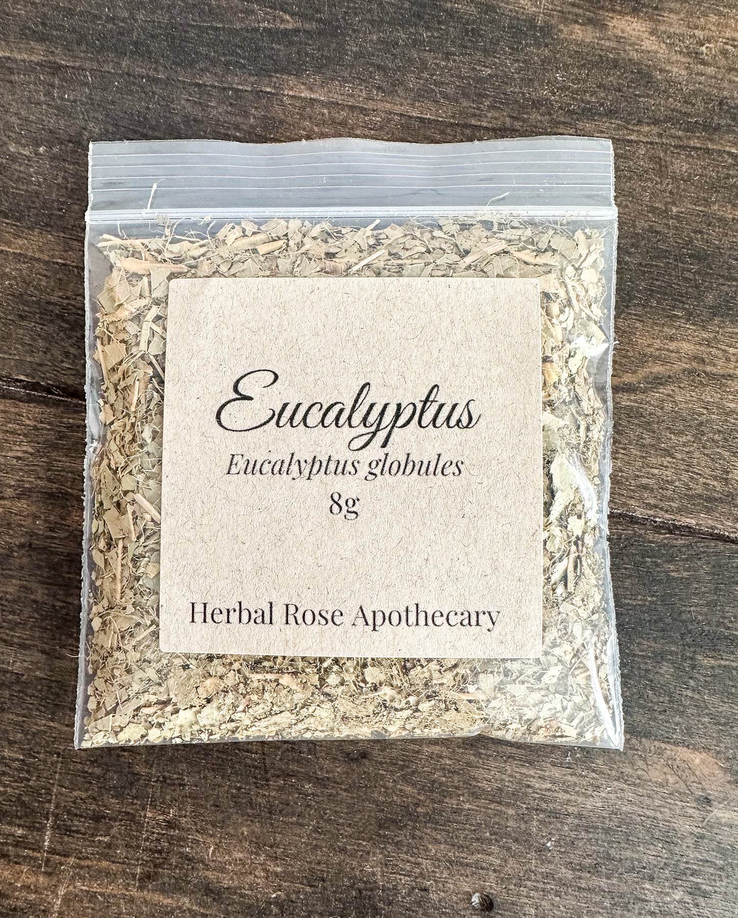 dried eucalyptus leaves in 8g clear resealable bag on wooden surface