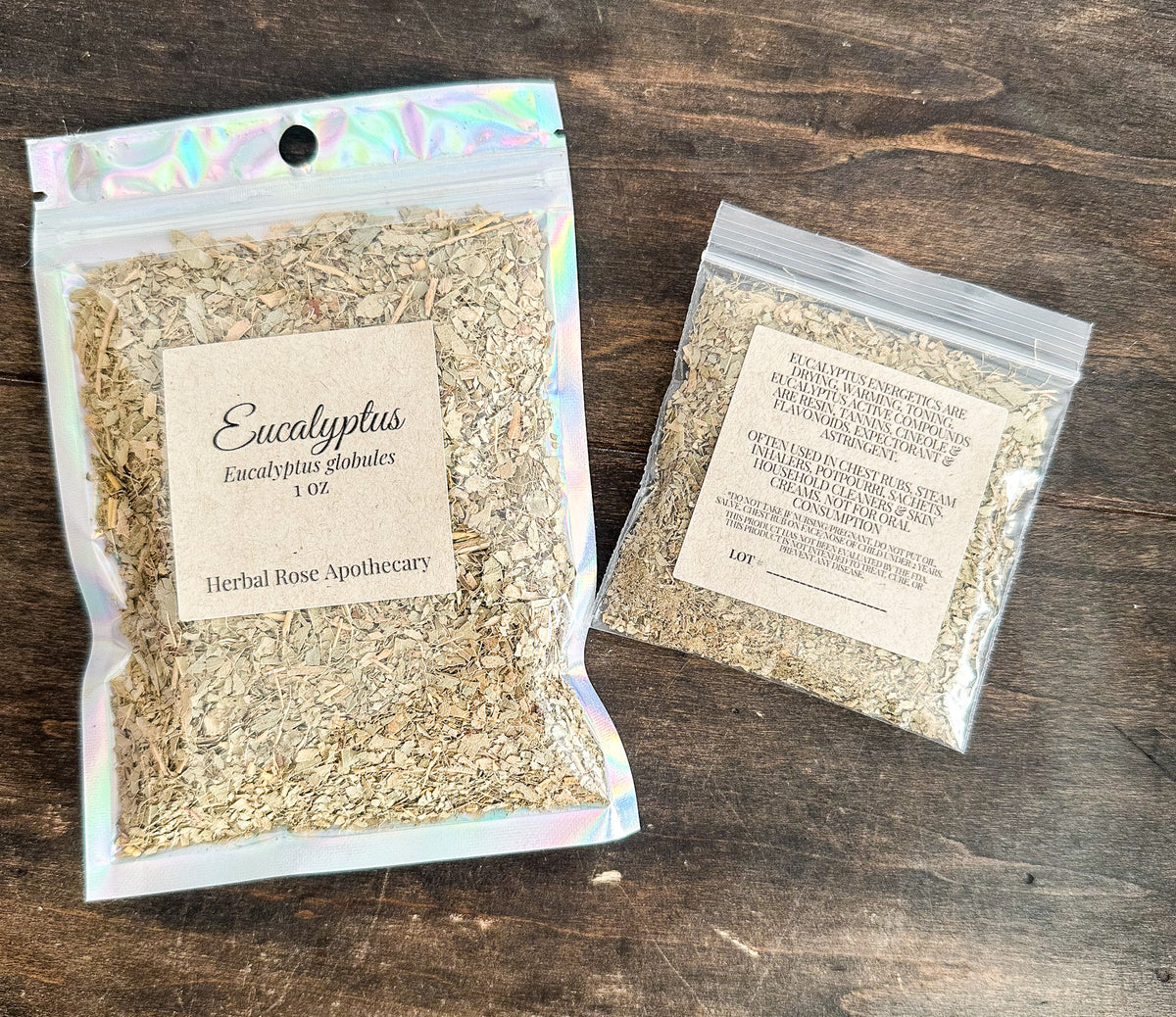 two packages of dried eucalyptus leaves in resealable bags from herbal rose apothecary on a wooden surface