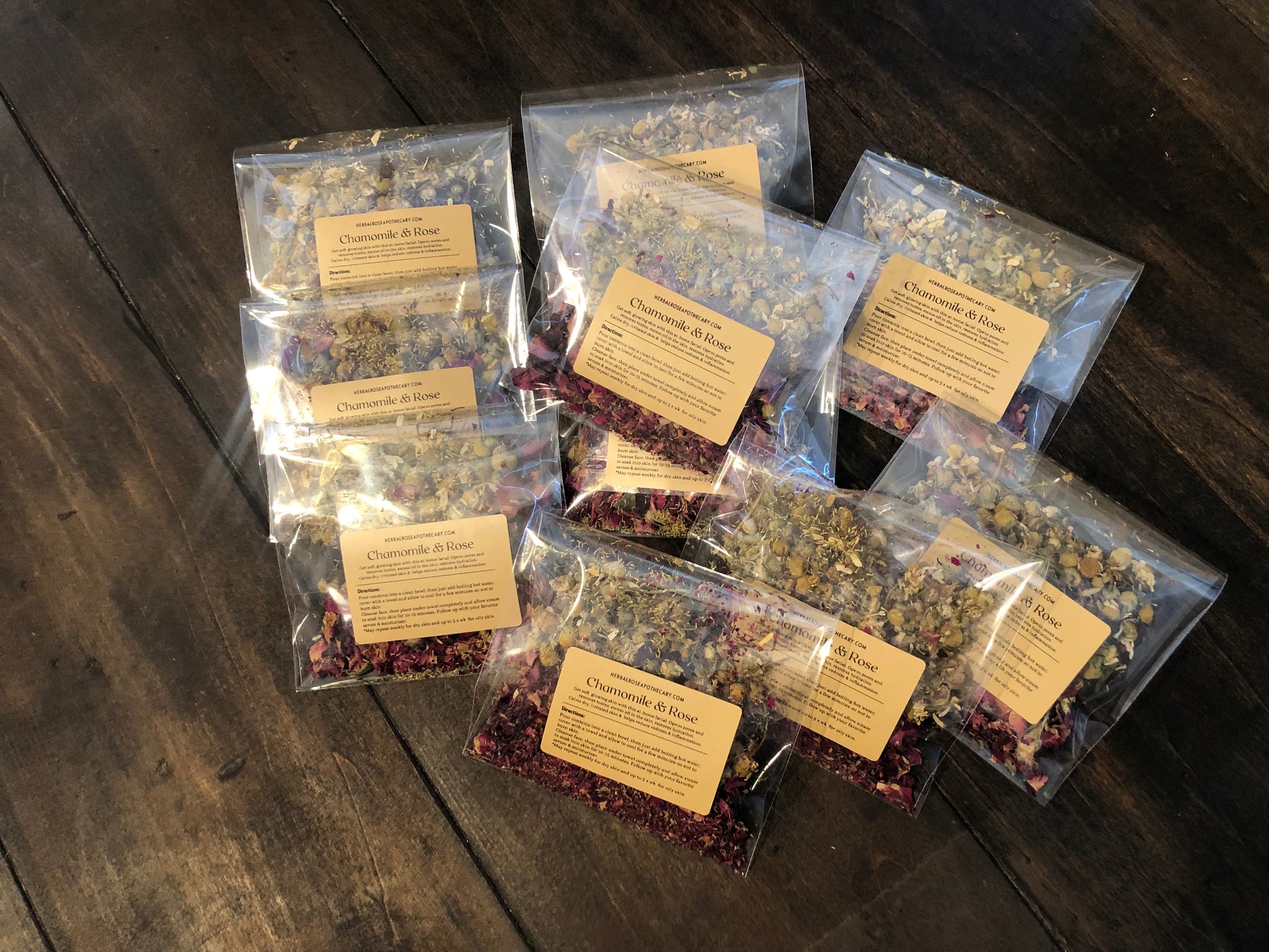 facial steamers packaged in clear bags piled up on a wooden surface with label showing directions and benefits