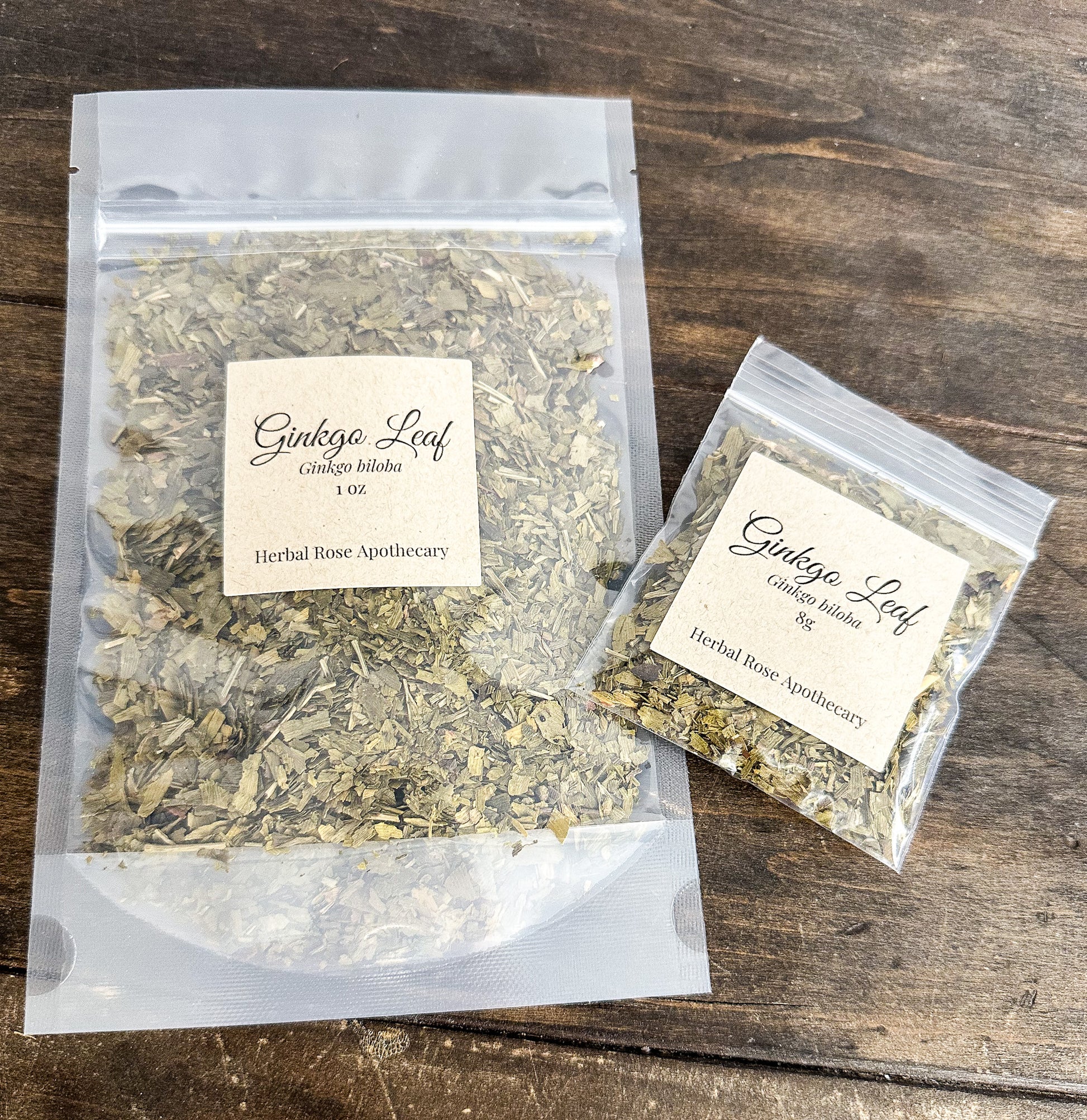 Two packages of Ginkgo Leaf from Herbal Rose Apothecary on a wooden surface.