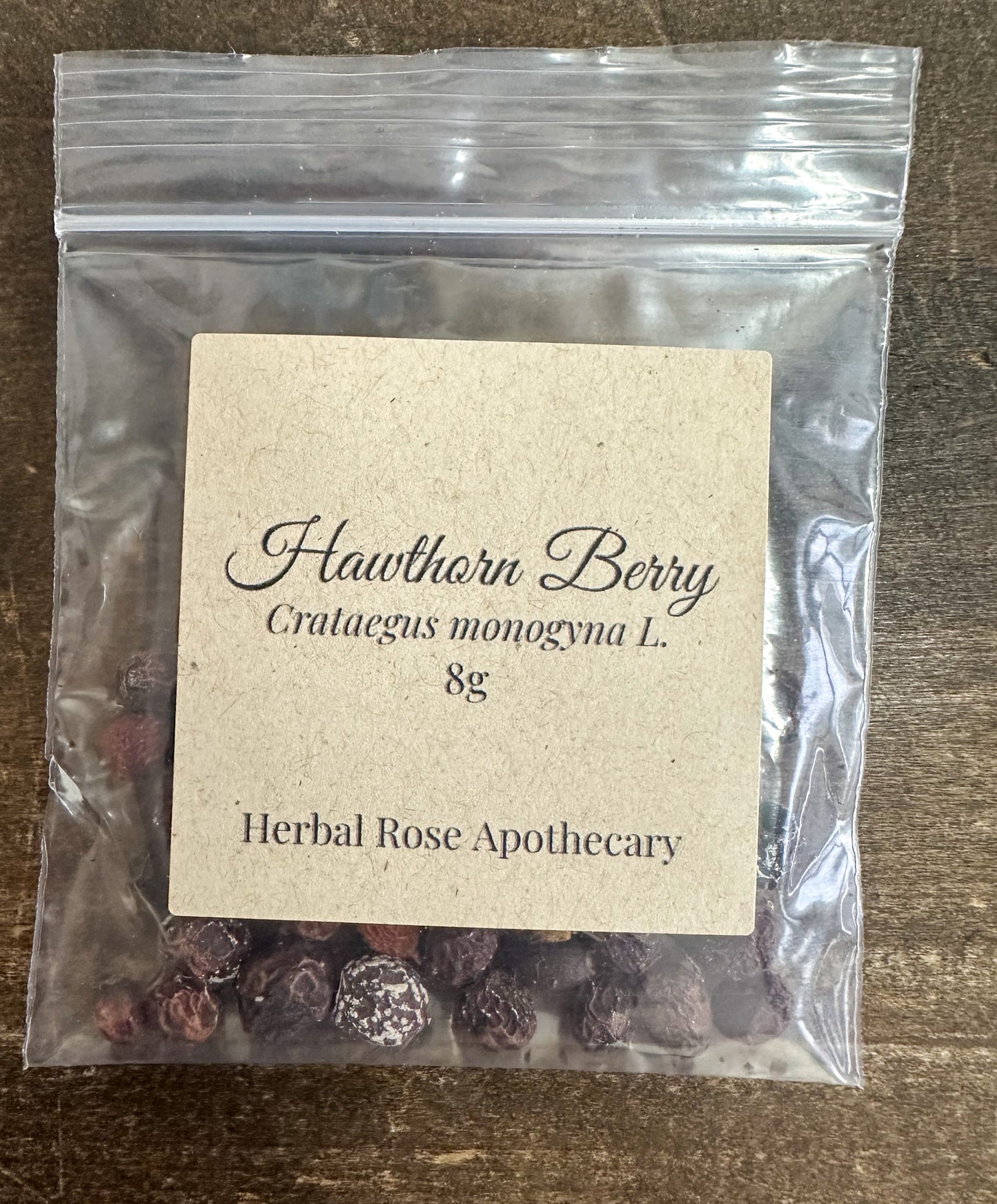 hawthorn berry 8g bag in clear bag on wooden surface from herbal rose apothecary