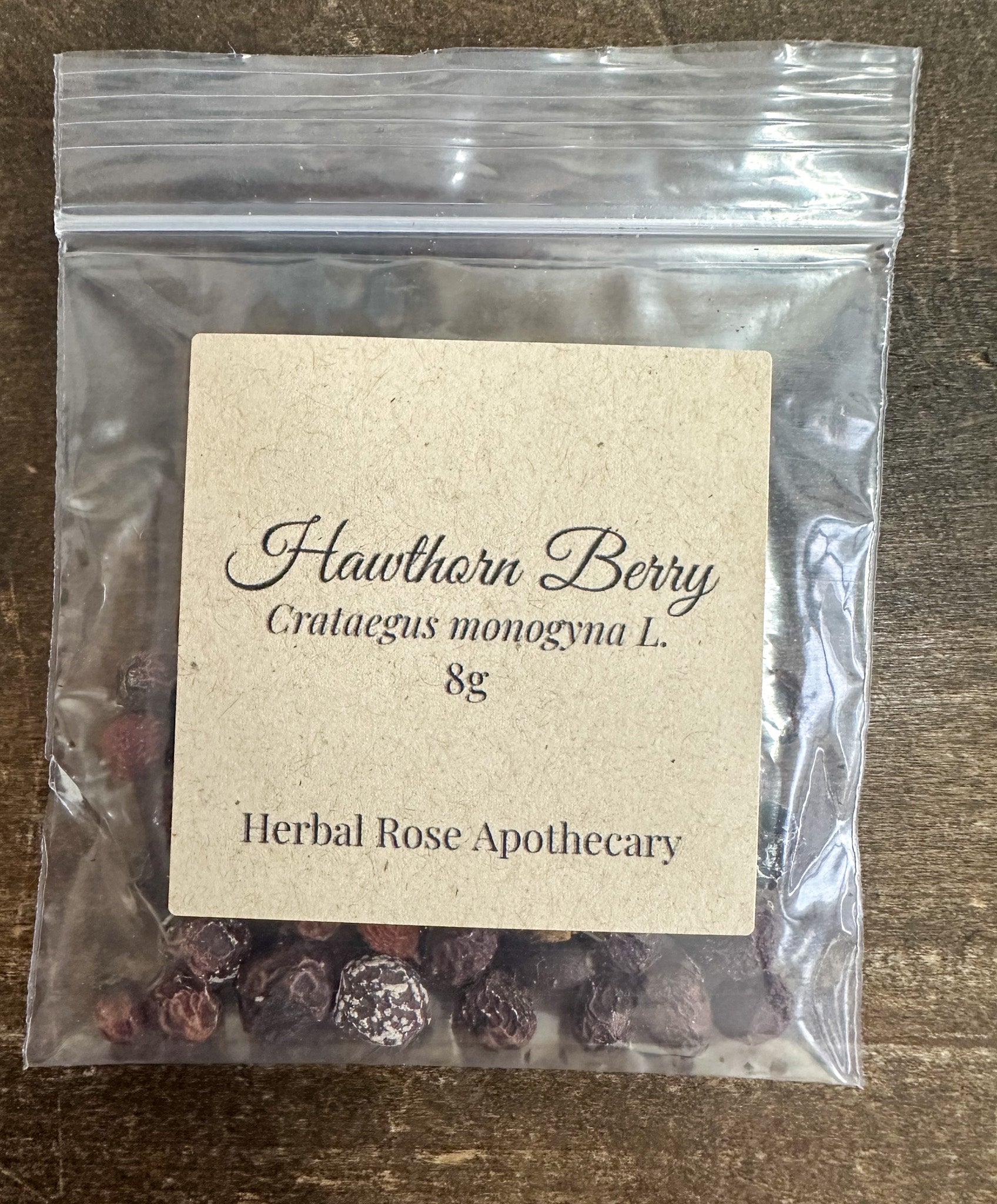 hawthorn berry 8g bag in clear bag on wooden surface from herbal rose apothecary