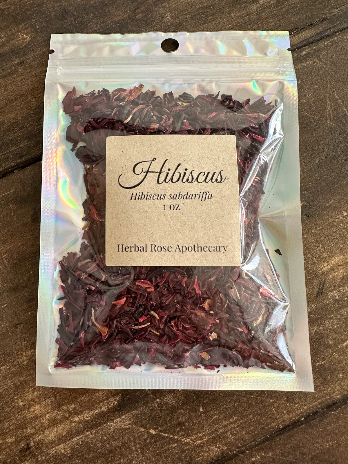 dried hibiscus 1oz bag in holographic bag on wooden surface