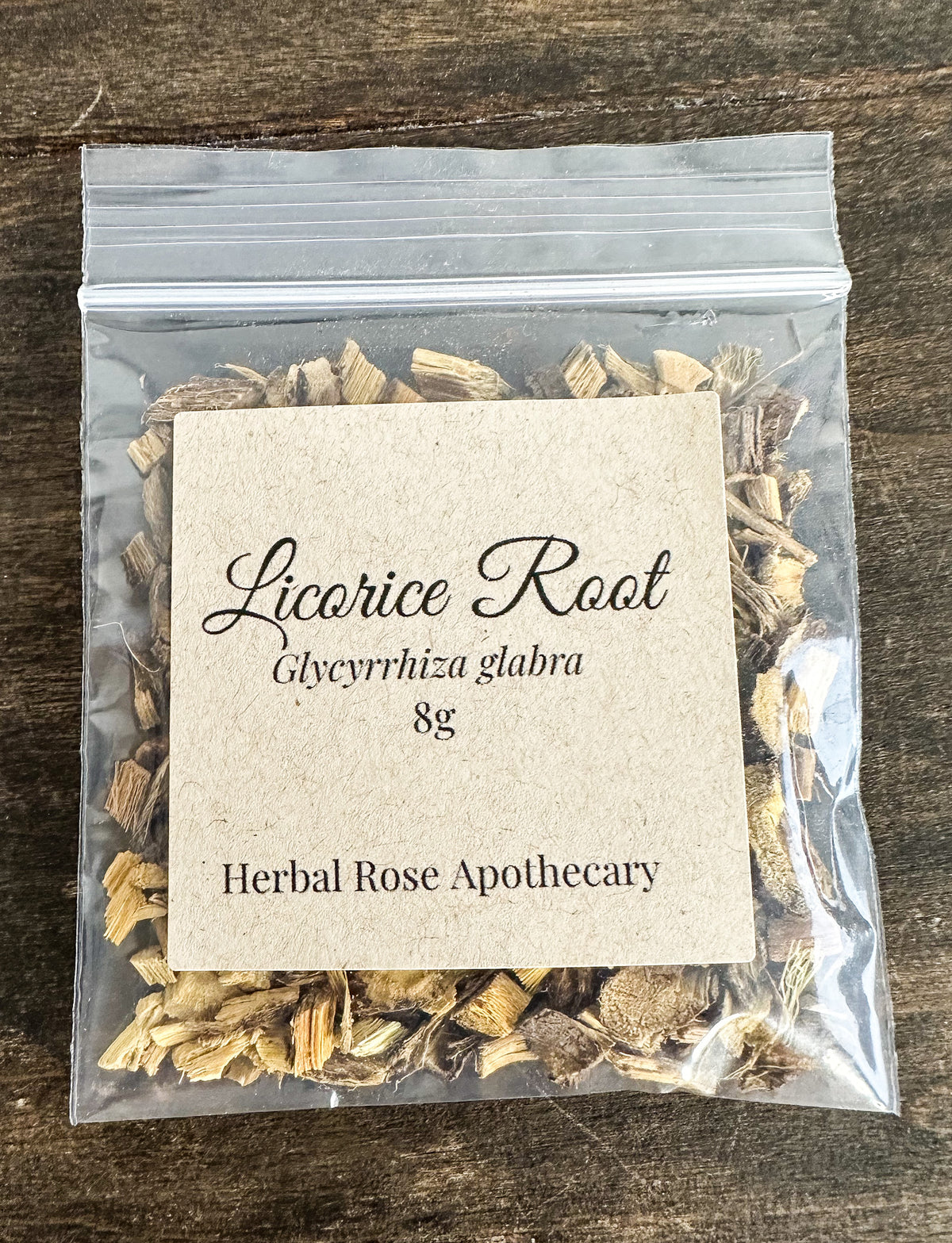 dried licorice root 8g bag in a clear resealable bag laid on a wooden surface