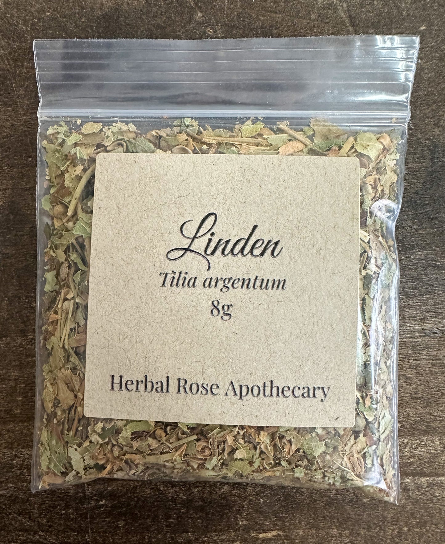 dried linden packaged into a clear 8g bag on a wooden surface