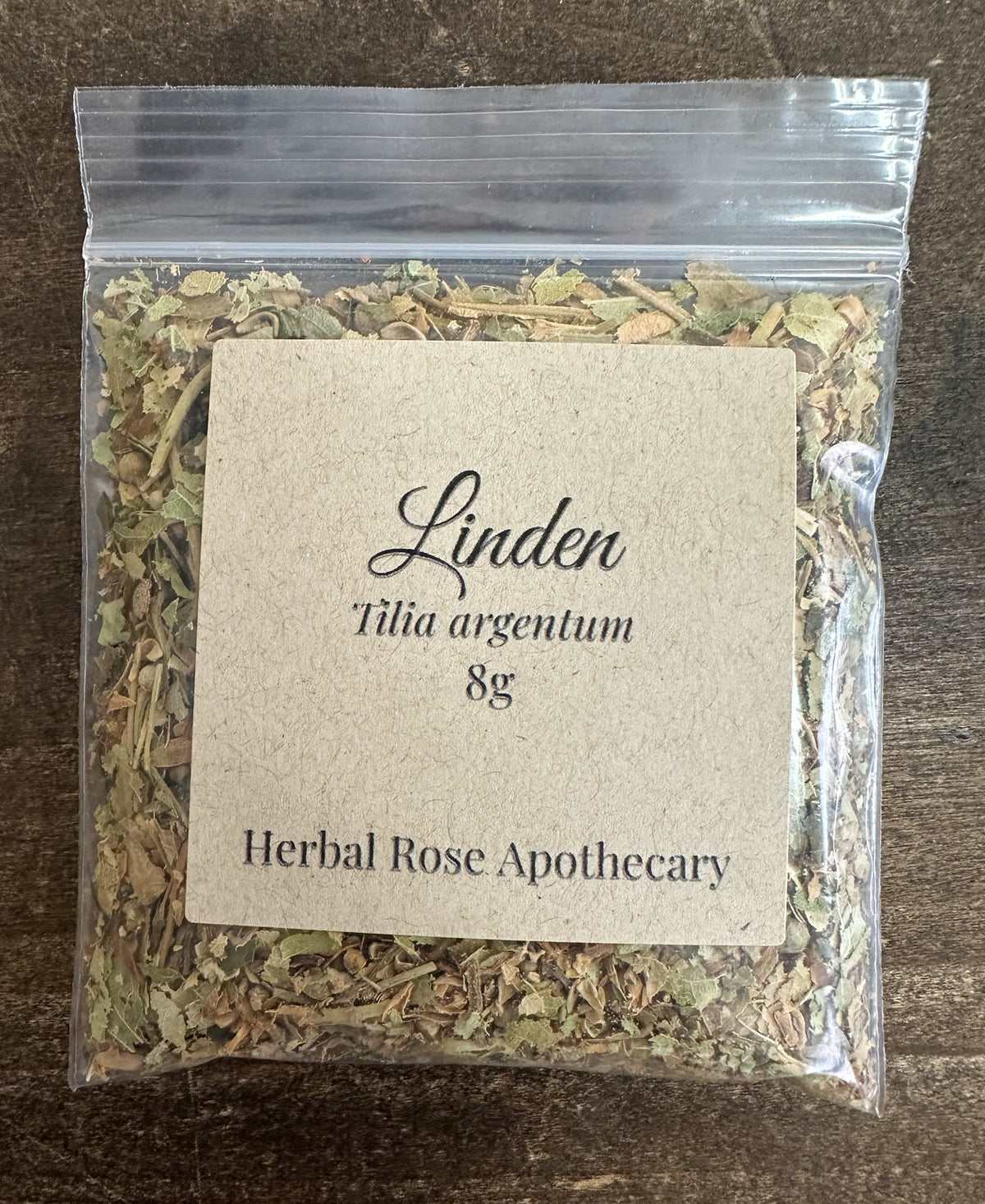 dried linden packaged into a clear 8g bag on a wooden surface