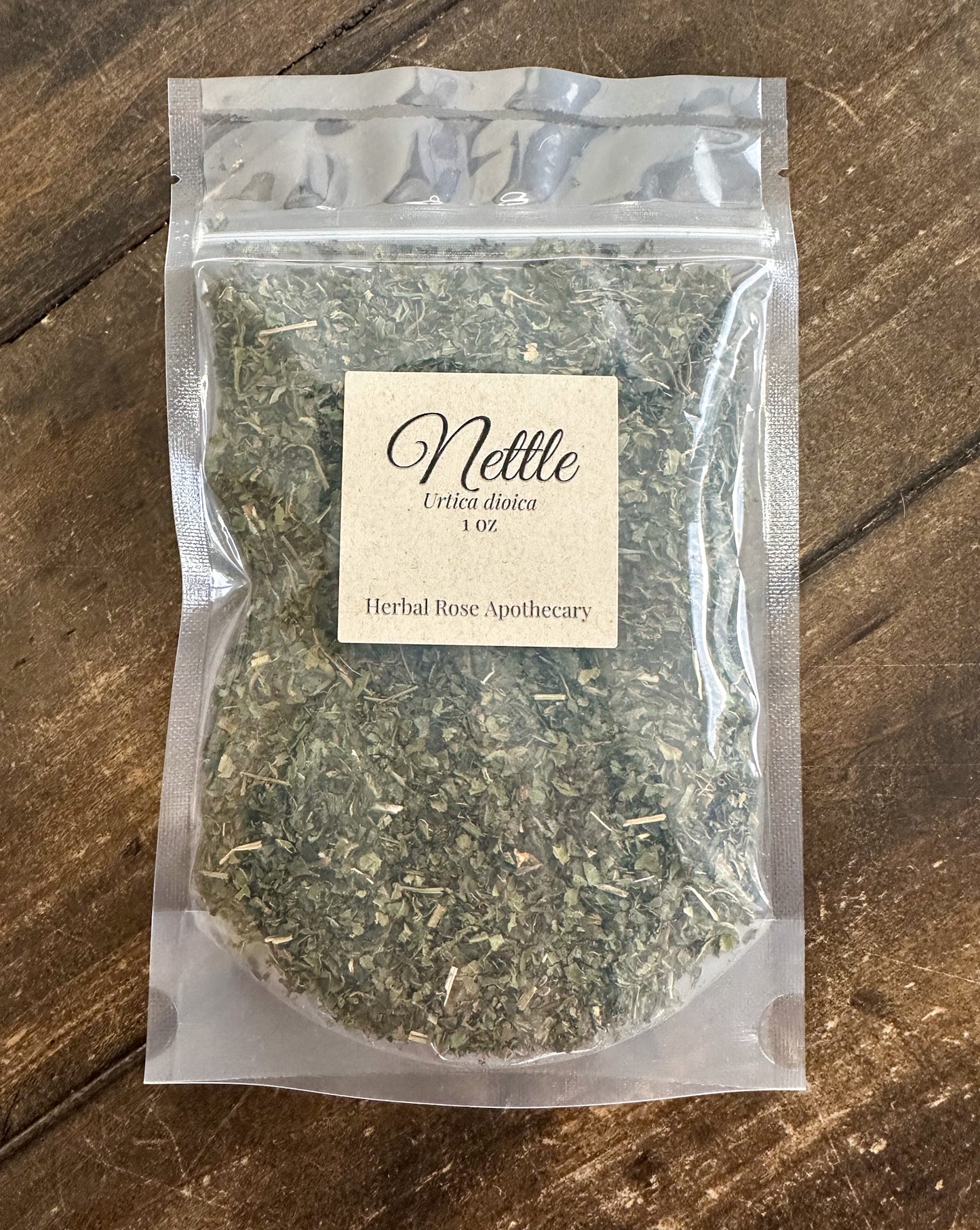 dried nettle leaves packaged into a clear resealable bag on a wooden surface