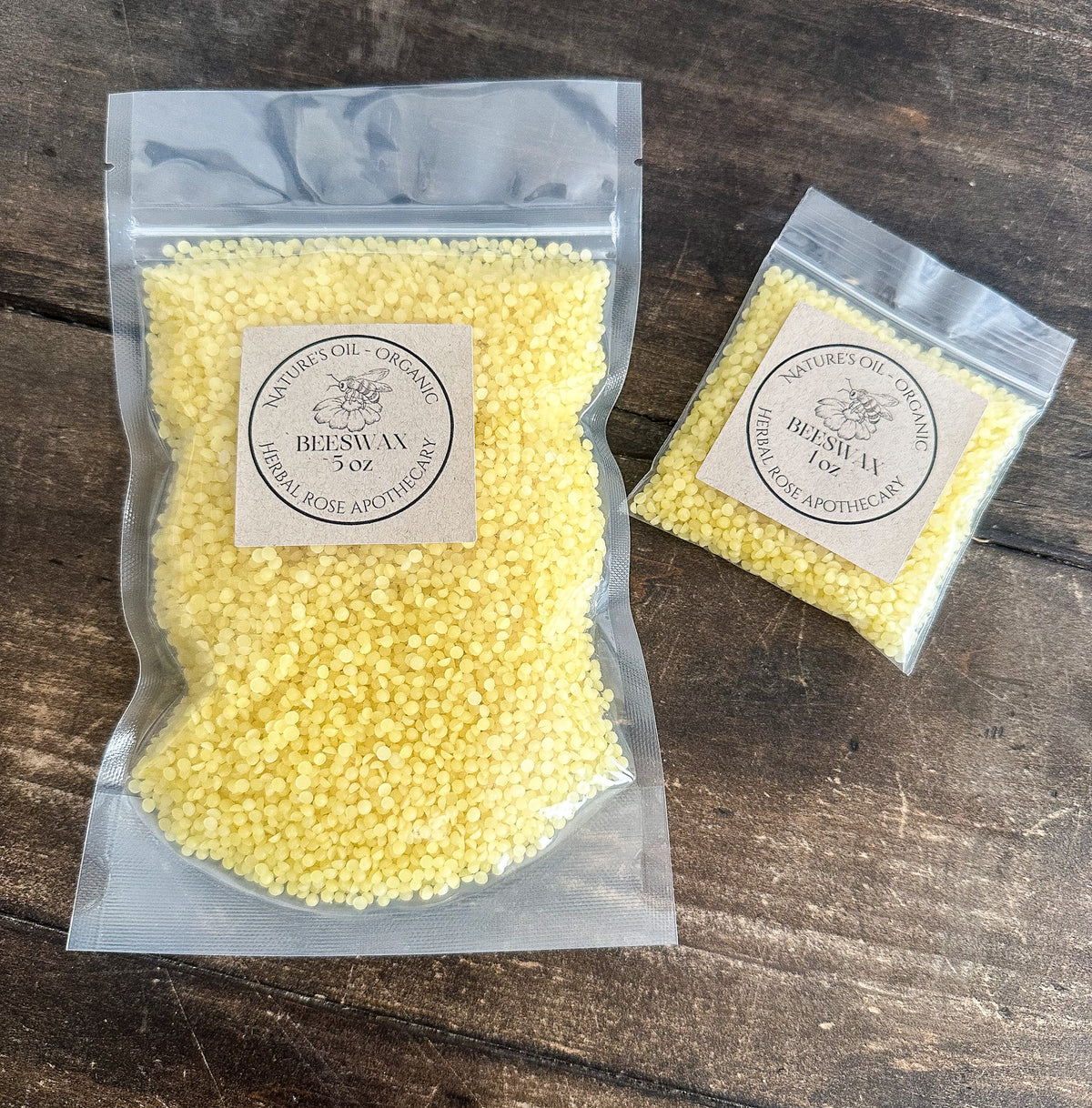 two packages of organic beeswax in clear resealable bags from herbal rose apothecary on a wooden surface