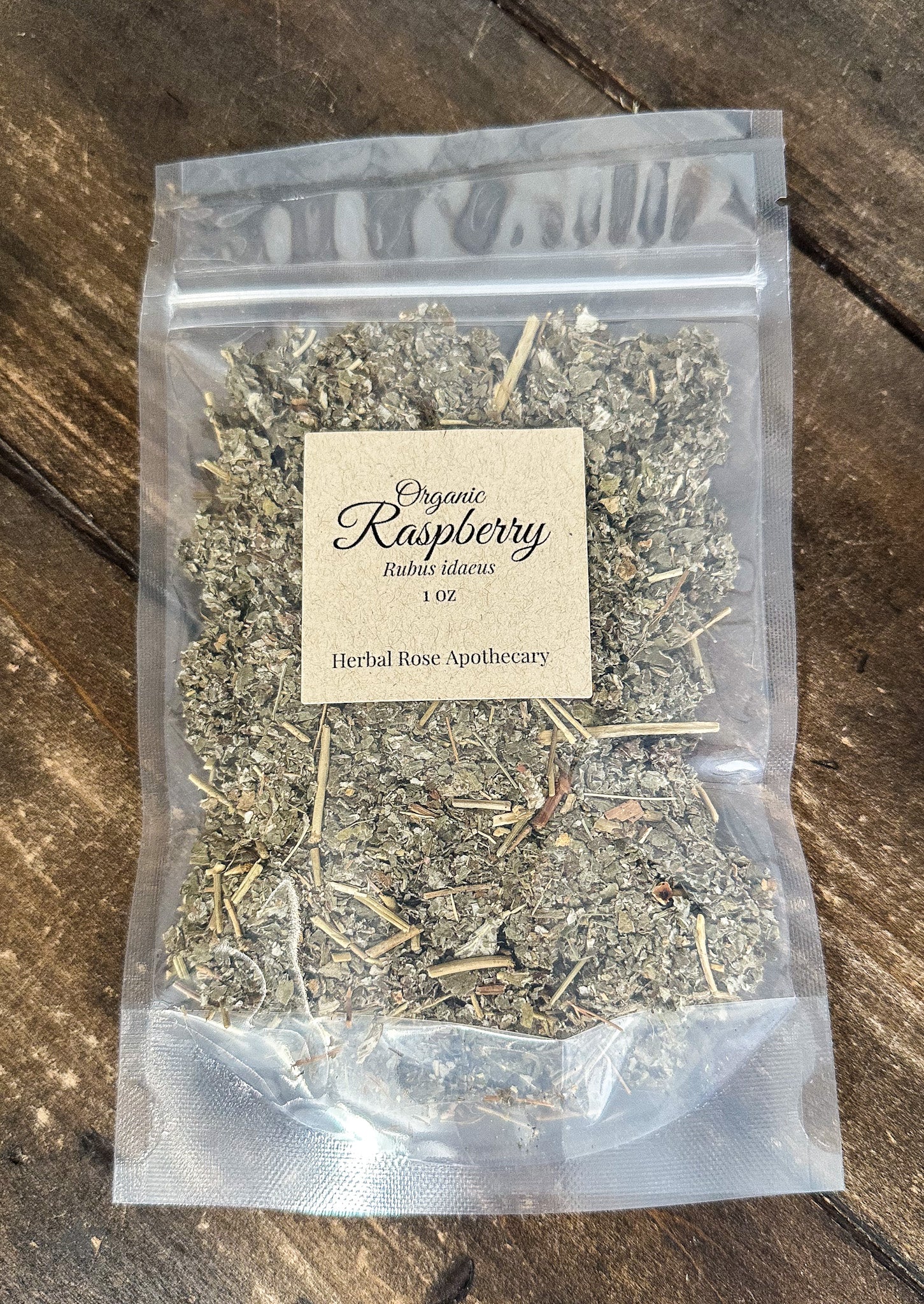 dried organic raspberry leaves in a 1oz clear resealable bag on a wooden surface