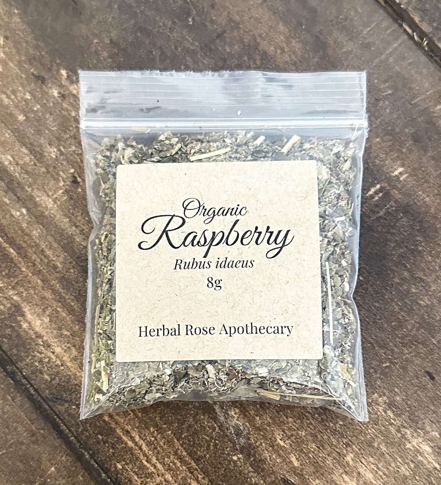 dried organic raspberry leaves in 8g clear resealable bag on a wooden surface