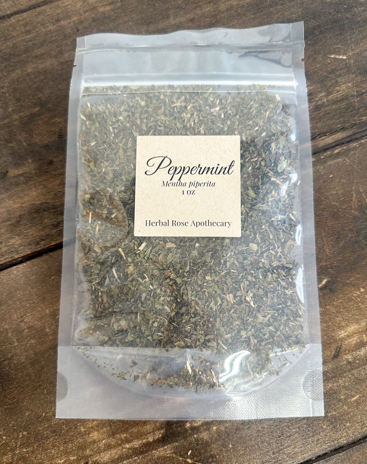dried peppermint 1oz bag in clear resealable bag on wooden surface