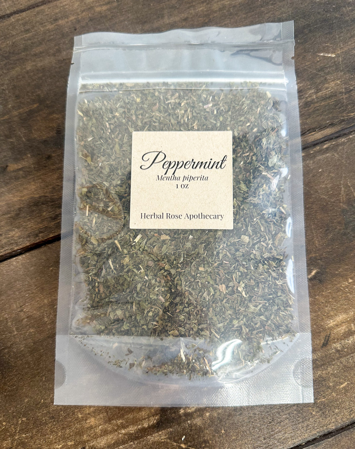 dried peppermint 1oz bag in clear resealable bag on wooden surface
