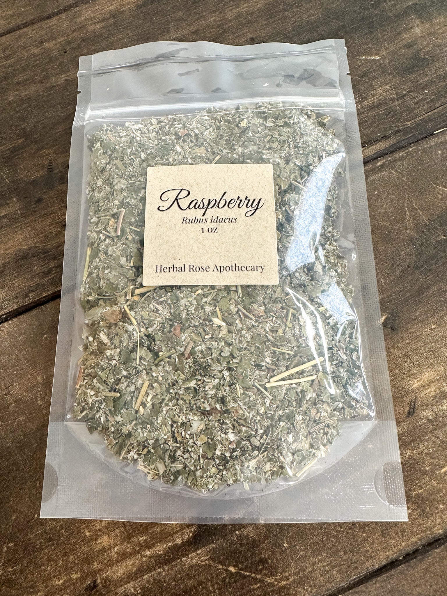 dried raspberry leaves in 1oz clear resealable bag on wooden surface