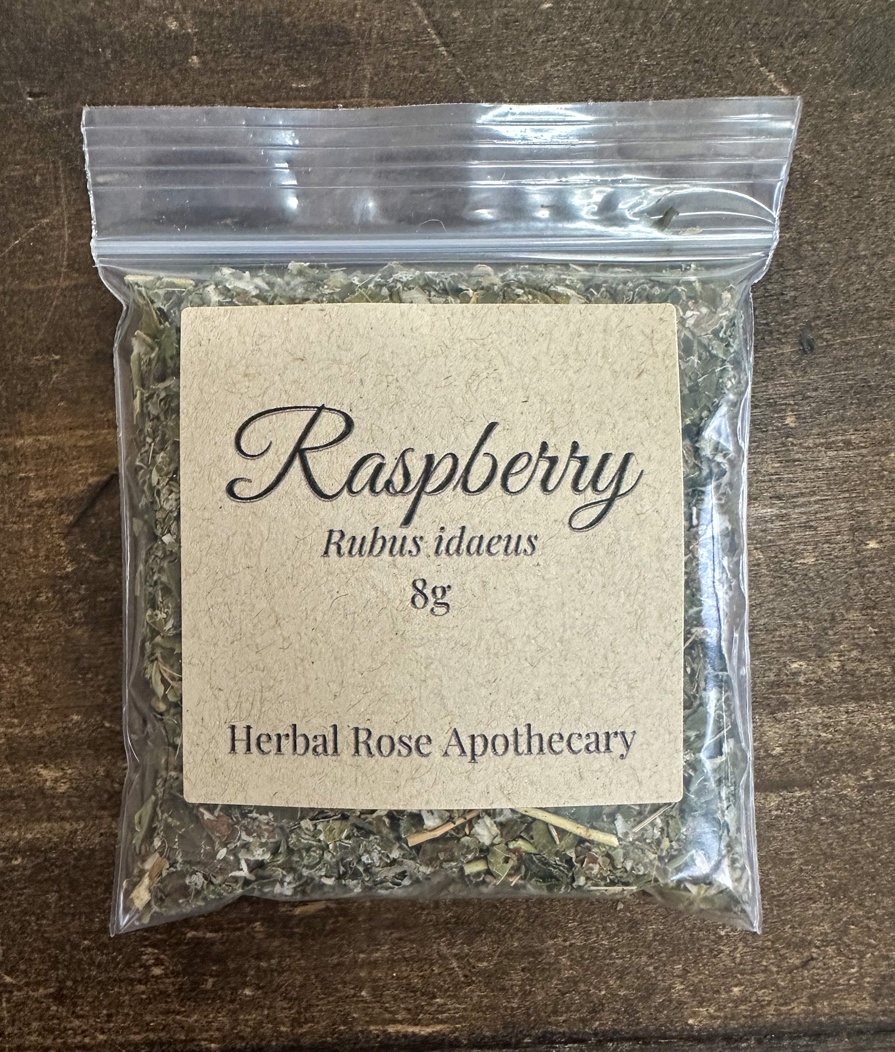 dried raspberry 8g bag in clear resealable bag on wooden surface
