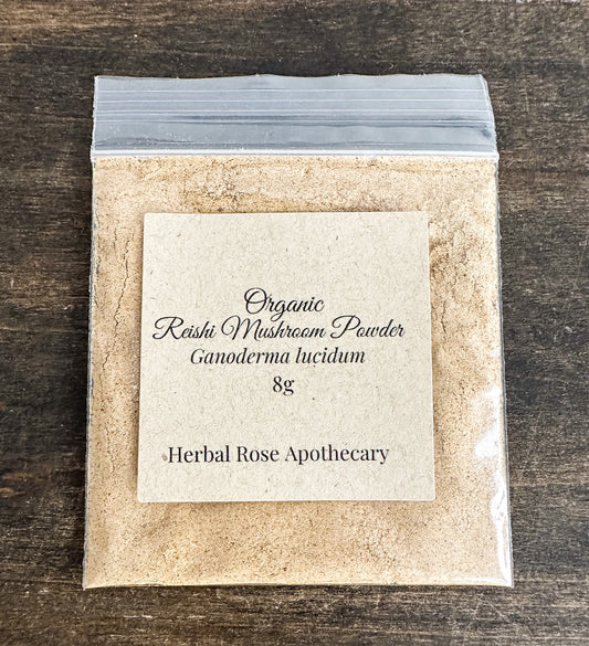 Packaged organic reishi mushroom powder with a label on a wooden surface