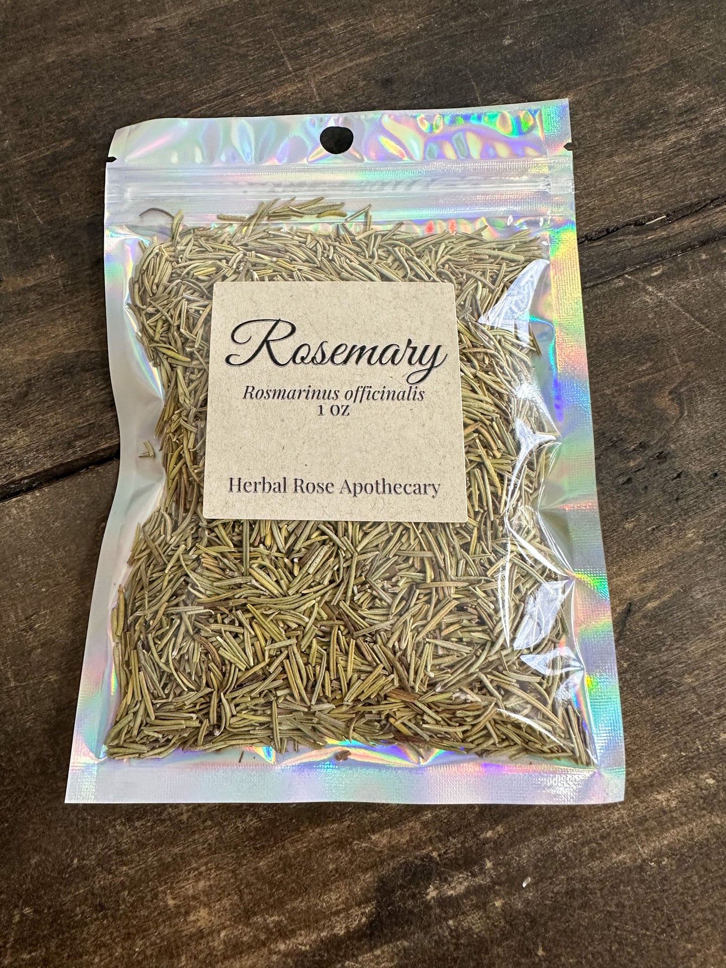 dried rosemary in 1oz holographic bag on a wooden surface