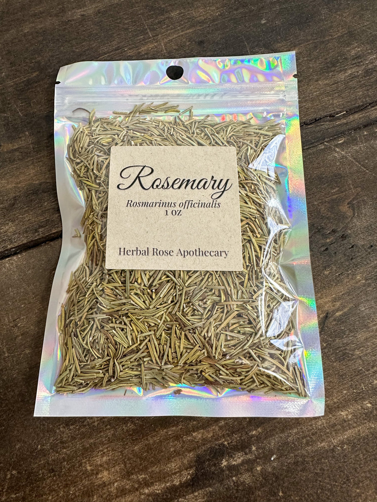 dried rosemary in 1oz holographic bag on a wooden surface